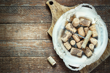 Wine corks and corkscrew on wooden table