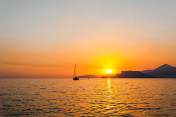 Tranquil nature scene of sailing boat in the ocean at sunset 