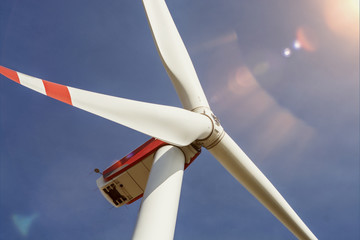 Windrad vor blauem Himmel im Sonnenschein