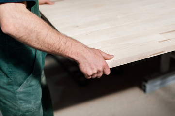 Obraz premium Man worker holding a big countertop in a furniture manufacture production.
