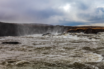 Water of the Godafoss Waterfall - beautiful part of stony rocky desert landscape of Iceland. Toned