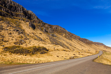 Asphalt road on the shore of the fjord in the east of Iceland