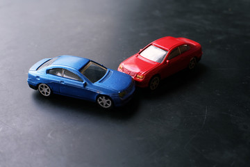 Fototapeta na wymiar Toy cars crash accident. Simulation red and blue car