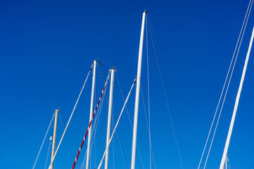 Sailboat masts against a blue Summer Sky 