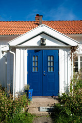 Beautiful vintage white wood house and blue doors in scandinavian style.