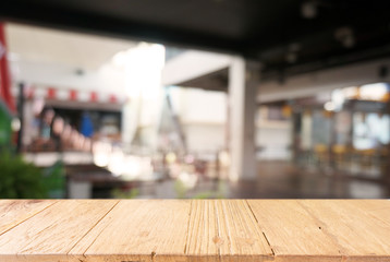 Empty dark wooden table in front of abstract blurred background of cafe and coffee shop interior. can be used for display or montage your products.