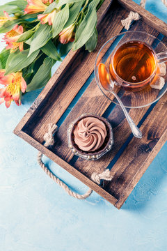 Picture of black tea in cup, cake with cream