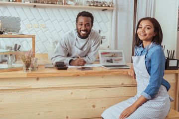 Charming baristas posing while discussing cafe website