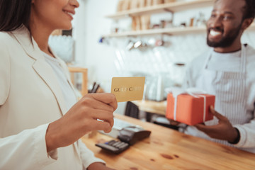 Female coffeehouse customer holding a golden card