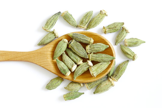 Dried okra (ladies' fingers, ochro) in wooden spoon isolated on white background. Top view