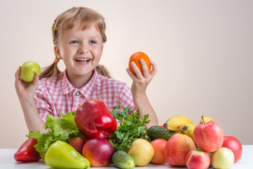 Fototapeta na wymiar Happy little girl and a lot of fruit and vegetables.
