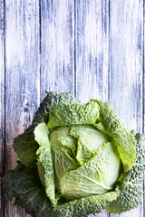 Raw savoy cabbage on wooden background. Organic food