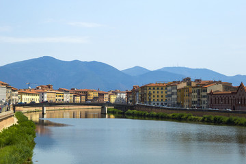 view on landscape of the bridge, the mountains and the river Arno in Pisa, Italy
