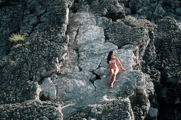 girl in bikini near rocks