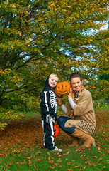 Fototapeta premium mother and daughter showing carved Halloween pumpkin
