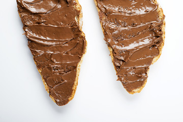 Chocolate spread on bread on white background. Isolated.