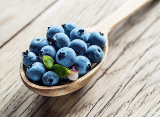 Blueberries in the wooden spoon on the table.