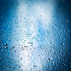 Liquid Serenity: Water Droplets on Blue Surface