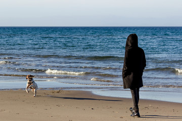 Donna passeggia al mare con cane