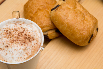 Light morning breakfast with croissant and coffee