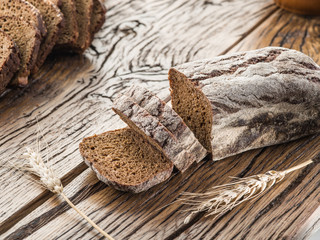 Sliced black bread on the wooden plank.