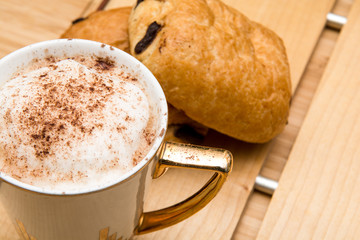 Light morning breakfast with croissant and coffee
