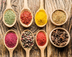 Assortment of colorful spices in the wooden spoons.