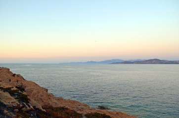 Scogli e tramonto in Europa. Mare, orizzonte e scogliera.