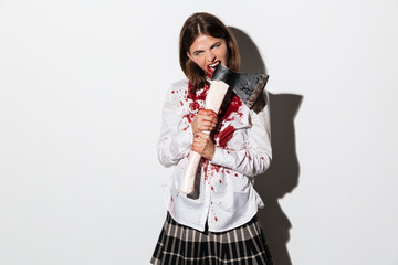 Bleeding scary zombie woman biting an axe