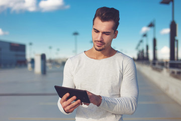 Young man using digital tablet outdoor, large space