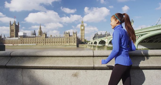 Woman running in London in front of Big Ben. Female runner on Westminster Bridge. Multicultural Asian Caucasian girl jogging training in London City, England, United Kingdom.
