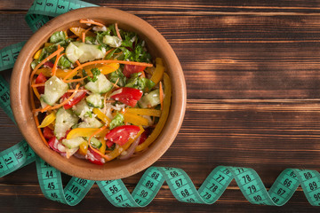 Organic vegetarian salad with vegetables and sauce.wooden plate on a wooden table