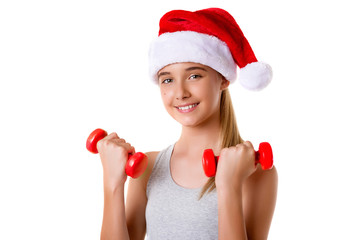 Fitness christmas girl training lifting hand weight wearing santa hat,isolated