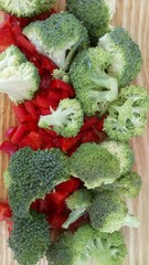 Broccoli and paprika lie on a wooden board