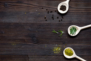 spices for cooking in spoon on wooden table top view