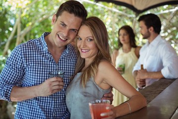 Portrait of couple having a glass of cocktail at counter