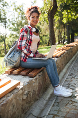 Fototapeta premium African woman sitting outdoors in park.