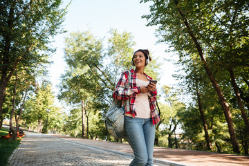 Cheerful young african woman walking outdoors