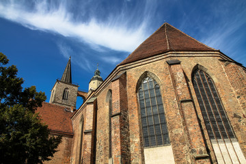 The gothic style Nikolaikirche (Saint Nicholas church) in the historical center of Jueterbog, Brandenburg, Germany in a sunny summer day with blue sky. Horizontal frame.
