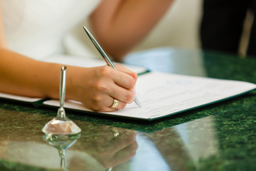 Businesswoman's hand with pen completing personal information on a form