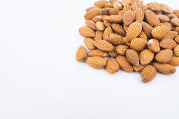 Almonds nuts in wooden ladle isolated on white background. Tasty medicine from nature.