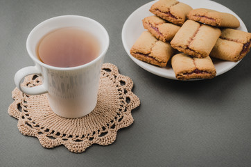 white cup and cookies on a grey background/white cup and cookies