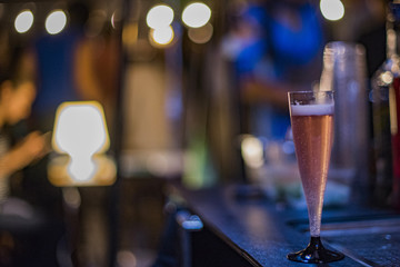 Closeup of a glass with pink drink at night