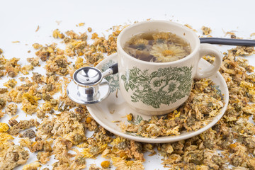 Dried yellow Chrysanthemum - Chrysanthemum tea is traditional Asian Chinese remedy to improve eyesight and clear liver heat. Concept stethoscope with Chrysanthemum is symbolic for healthy food