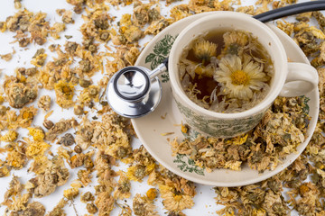 Dried yellow Chrysanthemum - Chrysanthemum tea is traditional Asian Chinese remedy to improve eyesight and clear liver heat. Concept stethoscope with Chrysanthemum is symbolic for healthy food