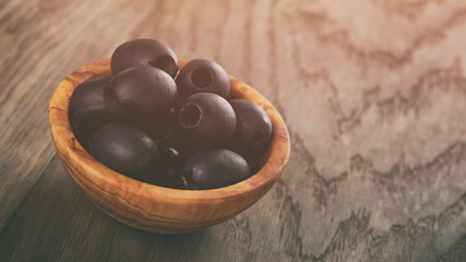 black olives from can in bowl on table