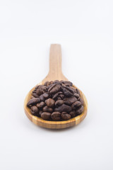 Concept roasted coffee beans in wooden ladle with isolated white background