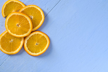 Fototapeta na wymiar Orange Slices on Top Left Corner with Blue Background