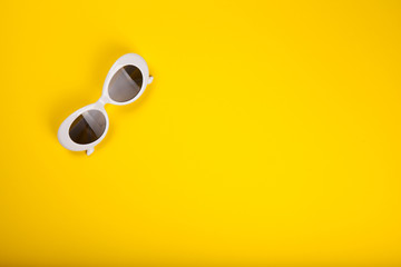 Stylish sunglasses on yellow background