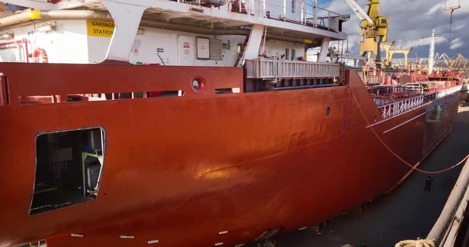 Workers repair and paint vessel at floating dock at the shipyard. Ship painters at work. Boat dyeing timelapse 4k video.